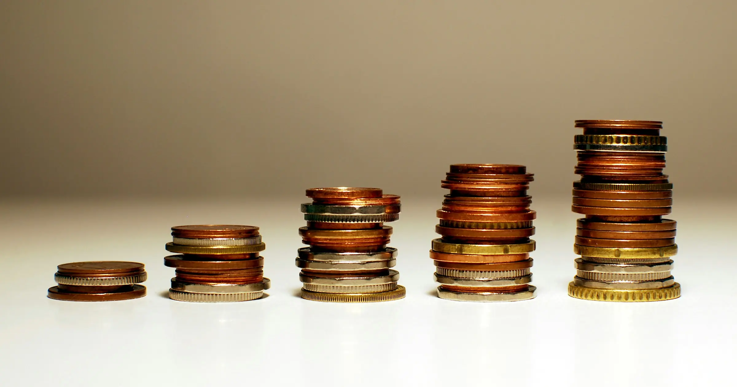 Five stacks of coins growing taller from left to right