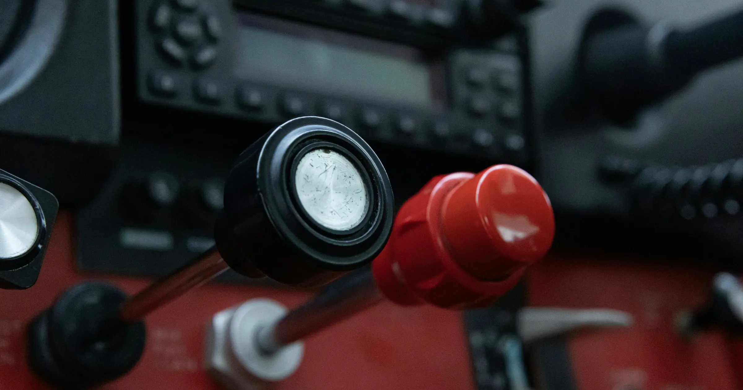 Close-up of a black and a red throttle control knob in a small airplane cockpit